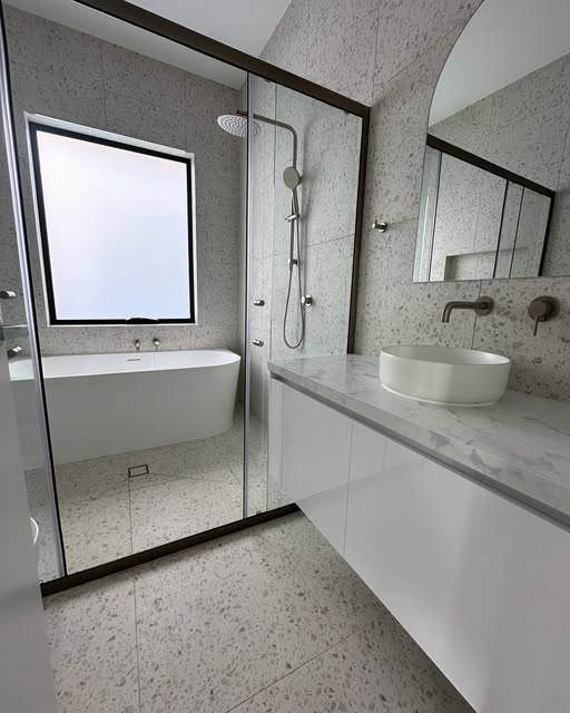 Lamassu terrazzo bathroom project with a freestanding bath and glass shower