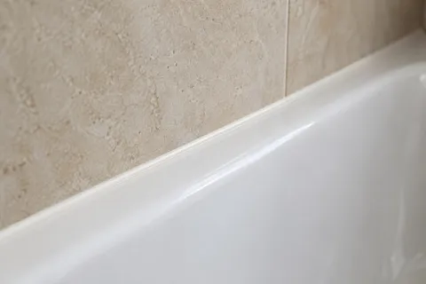 Illustration of a fine silicone joint between a bath and tiled wall